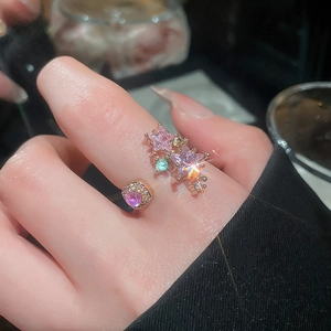 Close-up of rose gold open ring featuring pink star gemstones and green zircon detail