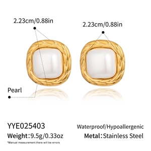 Detail of square vintage gold earrings with large pearl inlay and woven texture