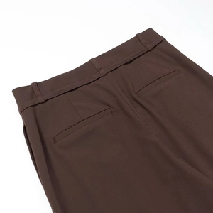 Détail d'un pantalon marron foncé avec passants de ceinture et coutures de poche