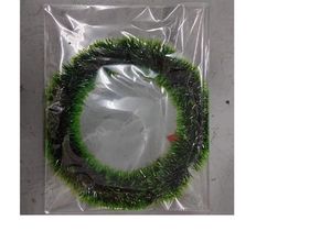 Detail of Christmas green and black tinsel garland coiled in clear packaging
