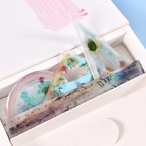 Detailed view of resin ruler set with embedded dried flowers and golden glitter