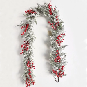 Detail of Christmas garland with realistic green pine needles, snow tips and red berries