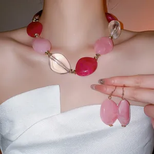Acrylic oval beaded necklace and earring set with translucent red and pink stones