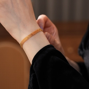 Gros plan détaillé du bracelet en maille plaqué or 18 carats sur le poignet d'une femme