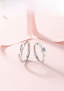 Close-up of S925 sterling silver couple rings with heart zircon on romantic pink background