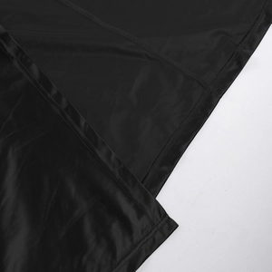 Detail view showing smooth black satin and fine knit texture stitching on a long dress