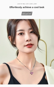 Close-up of a silver heart-shaped pendant necklace on a female model with pink gemstone