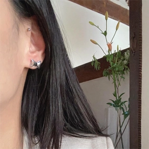 Minimalist 925 sterling silver bow knot earrings worn by a model in warm light