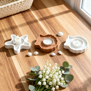 Handmade starfish and seashell candle holders on wooden table with warm sunlight