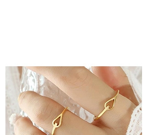 Detail of a minimalist gold teardrop open ring worn on a finger in a soft lifestyle setting
