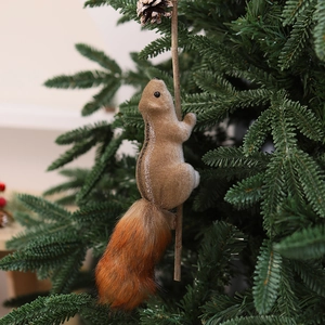 Close-up of realistic faux fur squirrel ornament hanging on a lush green Christmas tree