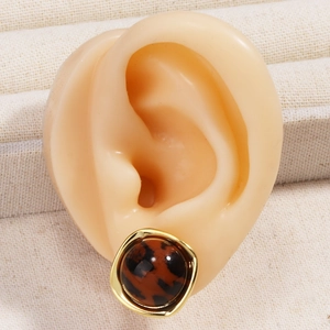 Nahaufnahme der Vintage-Ohrstecker mit Leopardenmuster und elegantem Goldrand