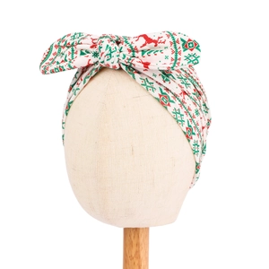 Close-up of baby headband with Christmas patterns including red reindeer and green snowflakes