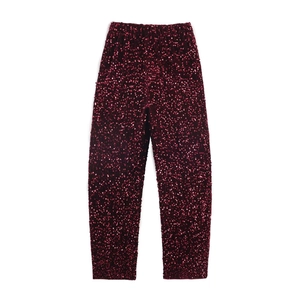 Detail of dark red sequined trousers featuring high-quality shimmering fabric and texture