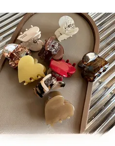 Detail of colorful acetate heart hair claws with Handmade France engraving on a tray