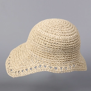 Detail of hand-woven straw hat showing intricate crochet pattern and brim hollow design