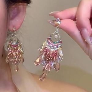 Detail of bohemian tassel earrings featuring colorful beads and painted flower glass