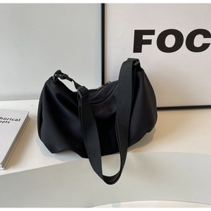 Macro detail of minimalist black nylon tote bag with adjustable wide shoulder strap