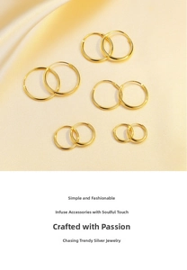 Five pairs of polished gold hoop earrings in various sizes on silk fabric