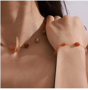 Detailed close-up of vintage gold necklace and bracelet set with natural agate stones