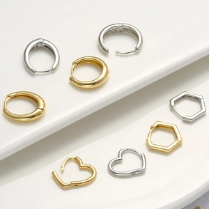 Macro shot of geometric gold and silver hoop earrings in round, heart, and hexagon shapes
