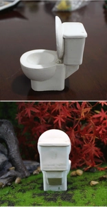 Vista dettagliata di un modello di toilette in miniatura in resina bianca in un micro paesaggio