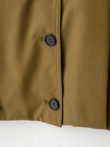 Macro view of khaki twill jacket showing fabric texture and black button detail