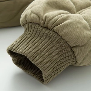 Détail du poignet en tricot coupe-vent et tissu matelassé de la veste bomber