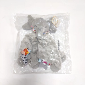 Détail du doudou éléphant gris en peluche avec tissu à pois sous emballage