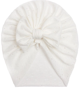 Detailed close-up of white lace baby headband with hollow wave texture and large bow