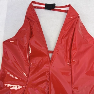 Detail of red glossy PVC halter neck dress with deep V-neck and slim fit texture