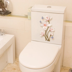 Dettaglio di fiori di magnolia rosa e farfalle blu adesive sul serbatoio del WC