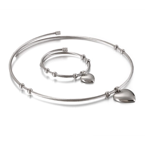 Silver twisted cable jewelry set with heart pendants and metallic beads on white background