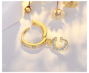 Detailed macro shot of a gold S925 silver earring with a sparkling pavé zircon letter G