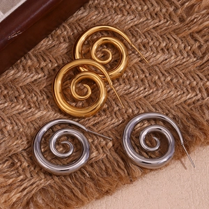 Macro shot of 18K gold and silver plated stainless steel spiral swirl stud earrings
