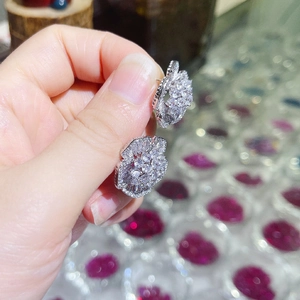 Macro shot of silver camellia earrings featuring dense white cubic zirconia pavé stones