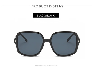 Detail of square black sunglasses showing silver star rivets and metal hinges