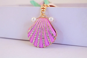 Detailed close-up of pink shell keychain with small diamonds and elegant pearls