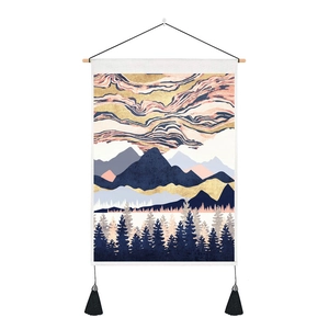 Detail of artistic tapestry with mountain landscape, wooden rod and black fringe accents