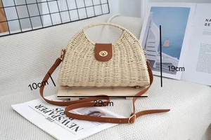Detailed size view of woven straw beach bag with brown leather trim and 29cm base length