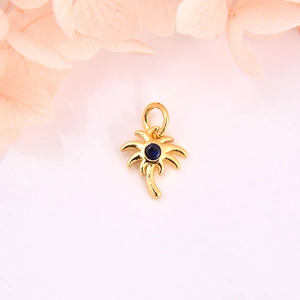 Detailed macro of gold palm tree charm with blue zircon for DIY jewelry accessories