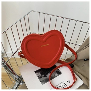 Dettaglio della borsa rossa a forma di cuore con scritte dorate su rete metallica