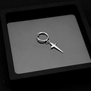 Macro detail of silver stainless steel cross star earring clip on a black jewelry box