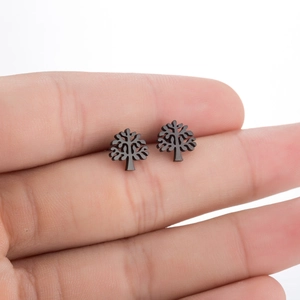 Detailed close-up of matte black Tree of Life stud earrings held between fingertips