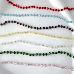 Macro view of multi-colored faceted crystal bead chains with gold wiring for necklaces