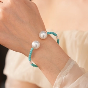 Gros plan d'un bracelet de perles turquoise avec de grandes perles blanches
