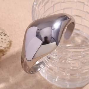 Macro detail of silver irregular curved bangle with a high-polished mirror finish