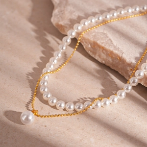 Detailed macro view of layered gold bead chain and premium white pearl choker necklace