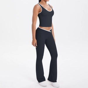 Détail d'un ensemble de yoga noir avec bordure blanche et pantalon évasé taille haute