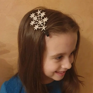 Detail of silver star hair clip with rhinestones worn on hair for styling